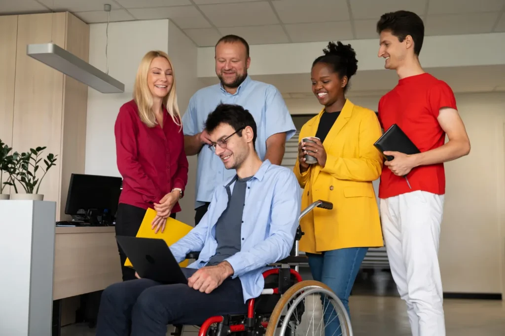 Inclusive office team working with a man in a wheelchair.